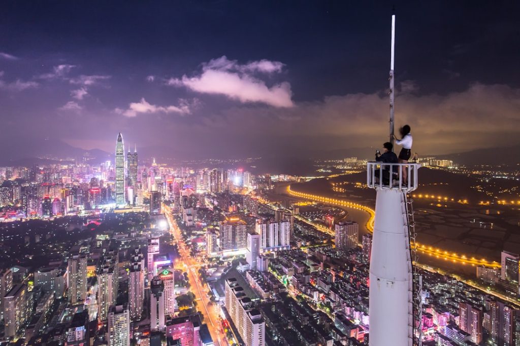 two-person-on-white-meta-tower-at-nighttine-icanqdrkykc Daredevils at the skyscraper spire